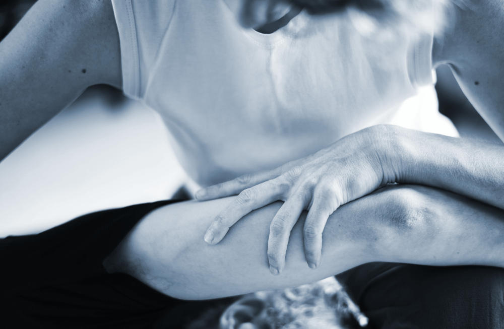 Marta stretches a client's arm over their head in a shiatsu treatment
